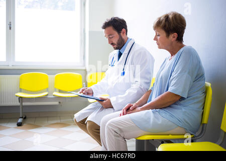 Doctor consulting patient in waiting room Stock Photo