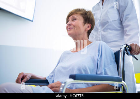 Doctor pushing senior patient on wheelchair Stock Photo