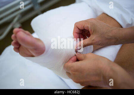 Doctor bandaging patients leg Stock Photo