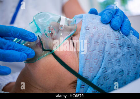 Patient wearing oxygen mask lying on hospital bed Stock Photo