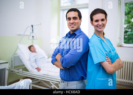 Smiling doctor and nurse standing with arms crossed Stock Photo