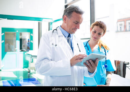 Doctor and nurse discussing over digital tablet Stock Photo