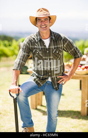 Smiling mature farmer holding a shovel and a watermelon isolated on ...