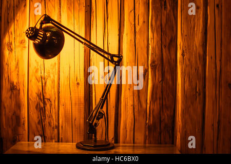 Table Top Lamp Lit Over a Wooden Textured Background. Copy Space. Stock Photo