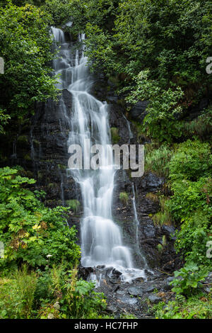 Small river near Valdez lake in Alaska flows over steep rocky terrain. This 25ft high waterfall is one of several falls as the river comes off the mou Stock Photo