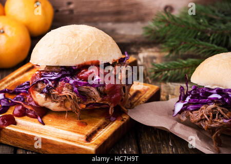Homemade bbq beef burger with crunchy red cabbage slaw on rustic table. Barbecue meat sandwiches for christmas lunch Stock Photo