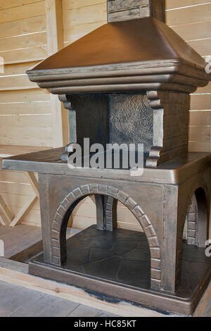 Newly built stone concrete grill placed in a wooden pavilion Stock Photo