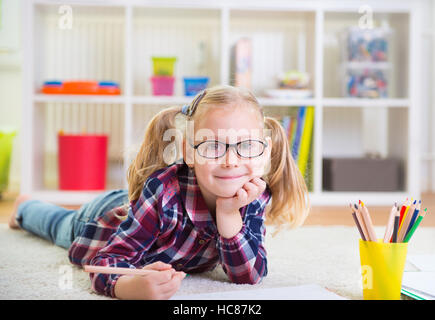 Cute little girl laying on floor at home Stock Photo