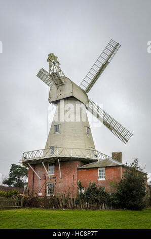 A white smock mill built in 1869 onto a two storey red brick base with attached miller’s cottage, Stock Photo