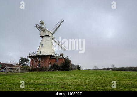 A white smock mill built in 1869 onto a two storey red brick base with attached miller’s cottage, Stock Photo