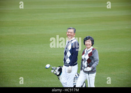 Smiling senior couple golfers walking Stock Photo