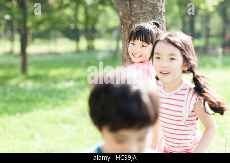 Portrait of three children playing in field Stock Photo