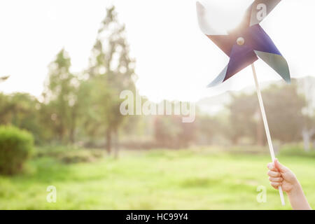Hand holding a pinwheel in field Stock Photo