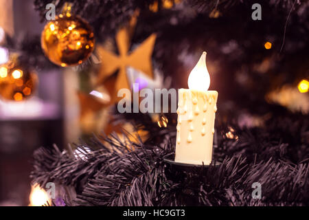 Christmas tree with a candle, a ball and a Maltese cross Stock Photo