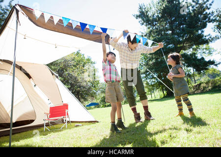 Loving father, son and daughter having fun at camping ground Stock Photo