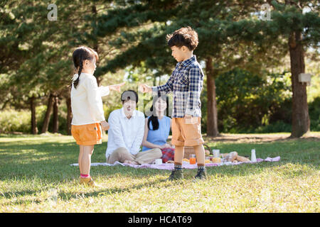 Harmonious family having a picnic under trees Stock Photo