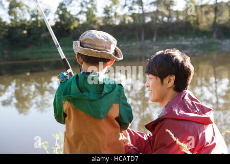 Back portrait of father and son fishing together Stock Photo