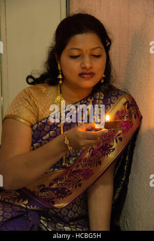 Young Indian woman with small earthen diya or lamp during Diwali Festival, Pune, Maharashtra, India Stock Photo
