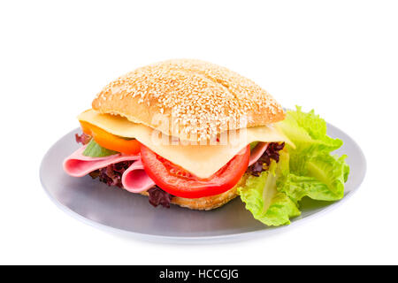 Sandwich with fresh vegetables, ham and cheese on plate. Stock Photo
