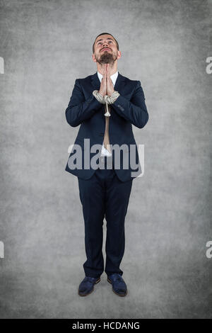 Arrested businessman praying Stock Photo