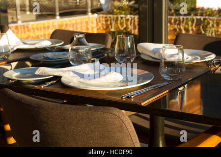 Table in the restaurant served for several persons with glasses, plates Stock Photo