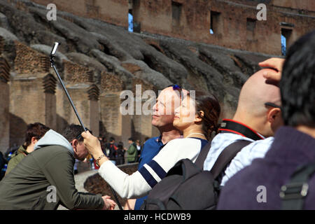 Couple taking a Selfie using a selfie stick inside the Coliseum in Rome, Italy Stock Photo