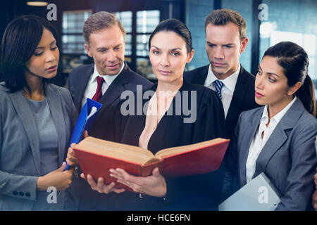 Lawyer reading law book and interacting with business people Stock Photo