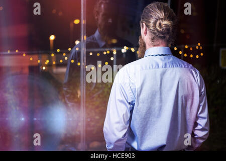 Businessman looking through window Stock Photo