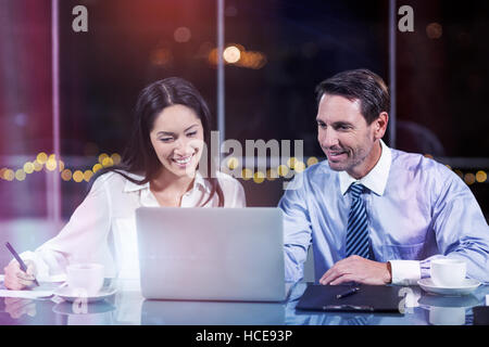 Businessman discussing with colleague over laptop Stock Photo