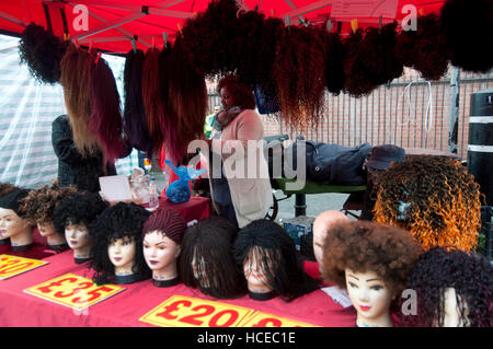 Hackney. Ridley Road market. Stall selling wigs and hairpieces. Stock Photo