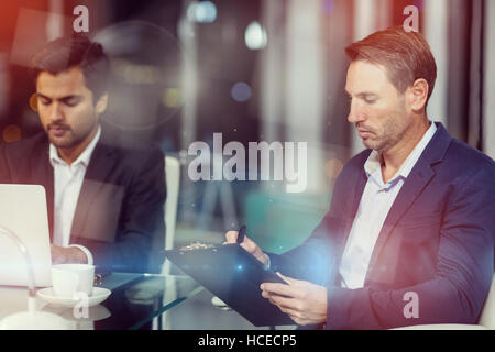 Businessman writing on clipboard Stock Photo