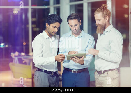 Businessmen discussing over digital tablet Stock Photo