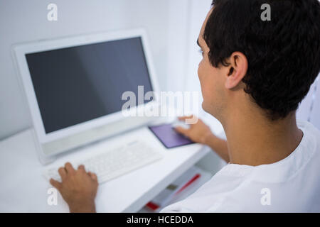 Dentist using computer at clinic Stock Photo