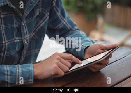 Man sitting at desk and using digital tablet Stock Photo