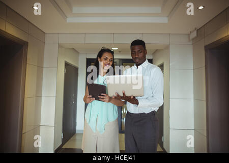 Businessman and a colleague using digital tablet and laptop Stock Photo