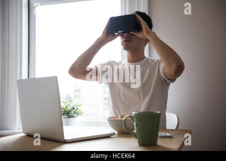 Man using virtual reality headset in living room Stock Photo