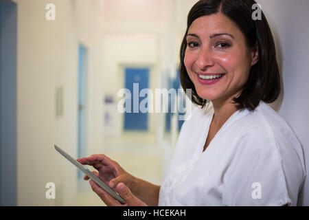 Smiling doctor using digital tablet at clinic Stock Photo