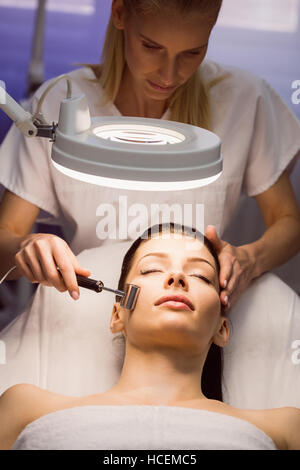 Dermatologist performing laser hair removal on patient Stock Photo