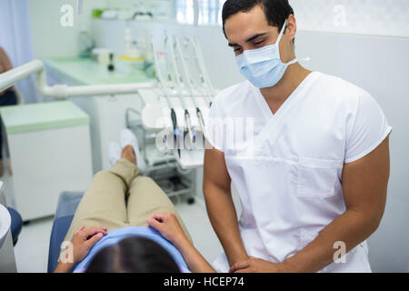 Doctor wearing surgical mask with female patient Stock Photo