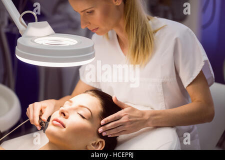 Dermatologist performing laser hair removal on patient Stock Photo
