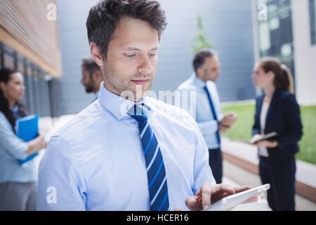 Confident businessman using digital tablet outside office building Stock Photo