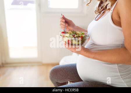 Pregnant woman eating  fresh healthy salad Stock Photo