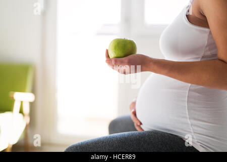 Healthy pregnant woman eating vitamin rich  apple Stock Photo