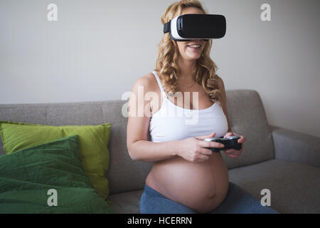 Beautiful pregnant woman enjoying VR Stock Photo