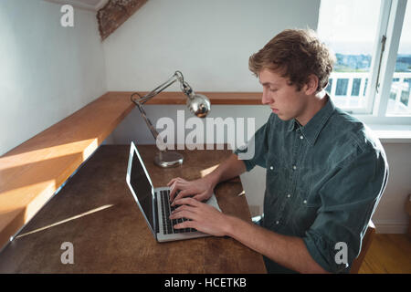 Man sitting at desk and using laptop Stock Photo