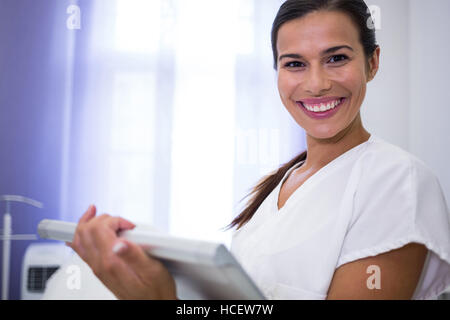 Smiling dentist using digital tablet Stock Photo