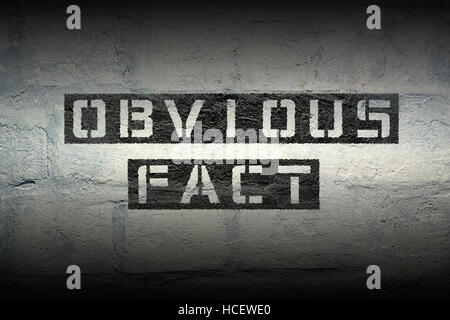 obvious fact stencil print on the grunge white brick wall Stock Photo