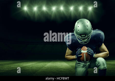 Composite image of american football player kneeling Stock Photo