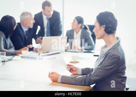 Side view of businesswoman reading report Stock Photo