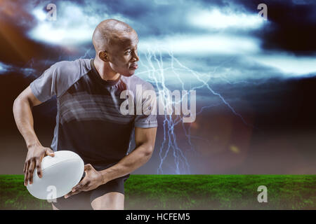 Composite image of athlete running with rugby ball Stock Photo
